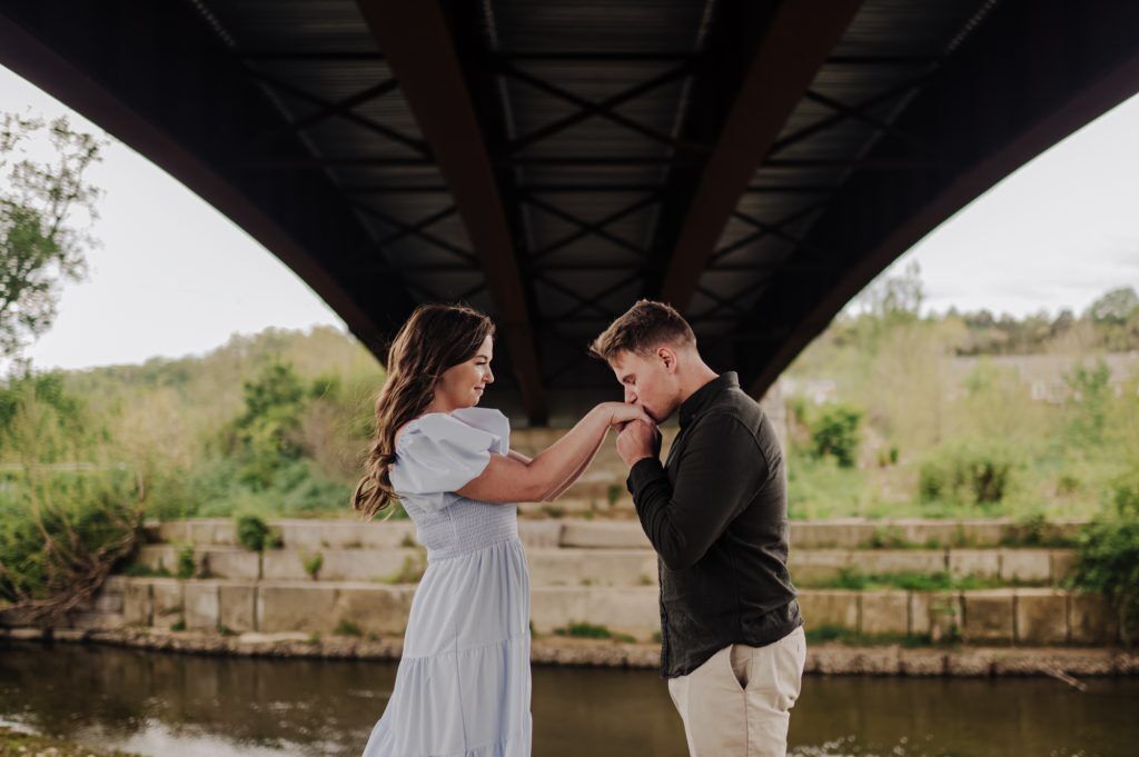 Boy takes girls hands in his and kisses them lovingly, thinking about the future they've planned together.