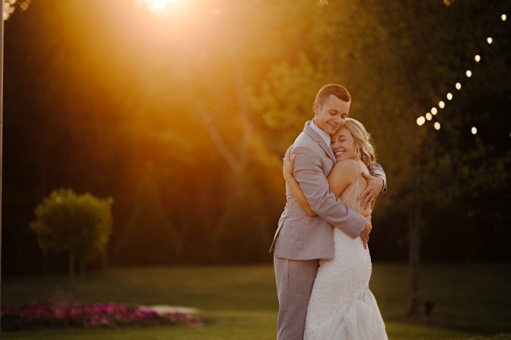 bride and groom celebrate their married during golden hour by holding each other tight