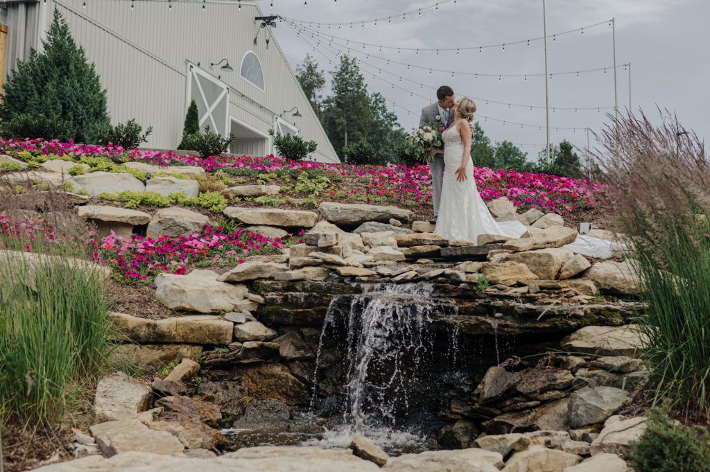 Bride and Groom share an intimate moment atop a waterfall outside the Woods at Cedar Springs