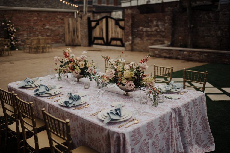 a tablescape of blues, peaches, and pinks fills the courtyard of the Prologue in New Albany Indiana