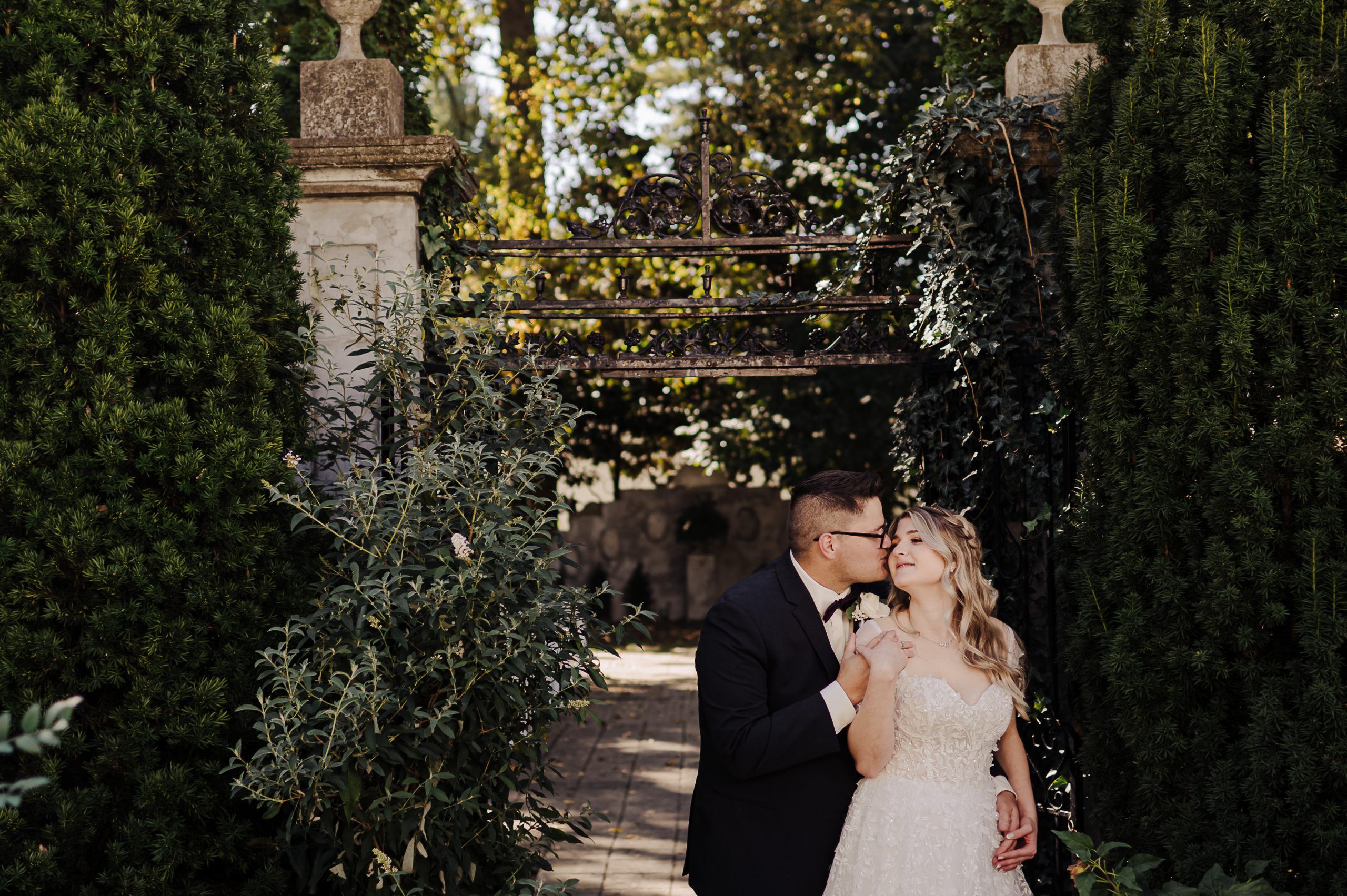 Garden wedding held at Gardencourt in Louisville, Kentucky. Couple snuggles together.
